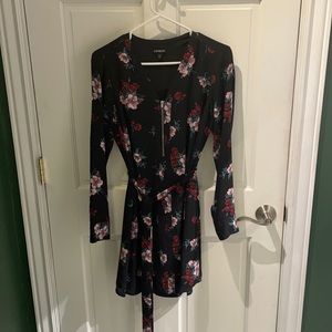Black dress with flowers and tie around waist.